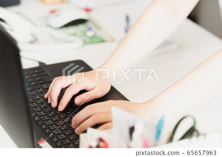 A woman working with a laptop 65657963