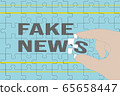 Hand holding a puzzle piece completing fake news words 65658447