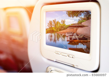 Aircraft monitor in passenger seat on beach pool Aircraft monitor in passenger seat on beach pool 65660097