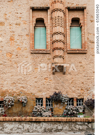 Red brick vintage building and plant pot garden of Ca l'Ordal house 65663040
