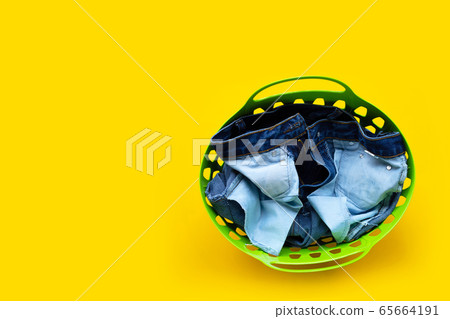 Jeans in green laundry basket  65664191