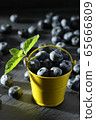 ripe blueberries in a small bucket on a gray 65666809