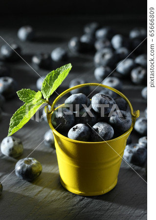 ripe blueberries in a small bucket on a gray 65666809