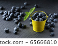 ripe blueberries in a small bucket on a gray 65666810