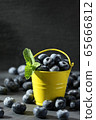 ripe blueberries in a small bucket on a gray 65666812