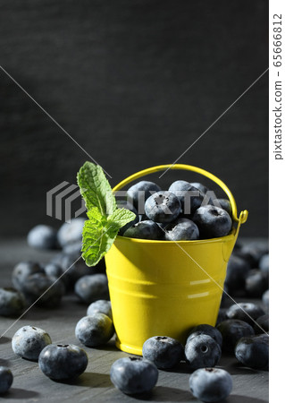 ripe blueberries in a small bucket on a gray 65666812