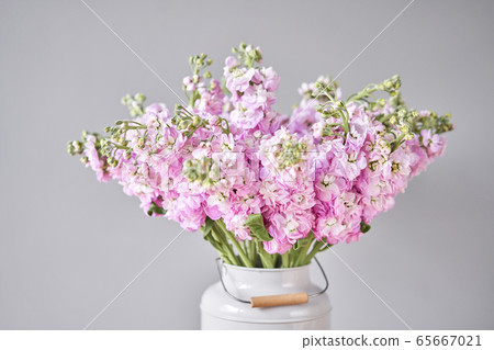 Bouquet of Beautiful lilac mattiola. Spring flowers in vase on wooden table. Flowers delivery. 65667021