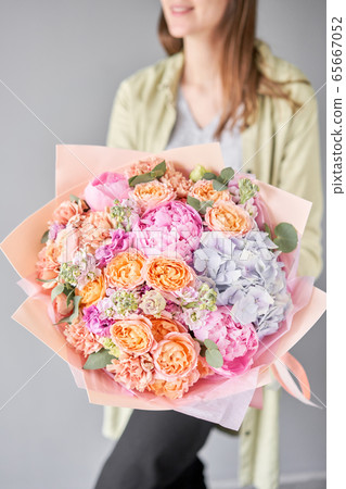 Pink peonies and hydrangea. Beautiful bouquet of mixed flowers in woman hand. Floral shop concept . Handsome fresh bouquet. Flowers delivery. 65667052