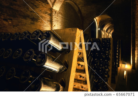 Pupitre and bottles in an underground cellar Pupitre and bottles in an underground cellar 65667071
