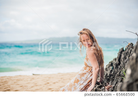 A girl sits on a rock on the beach of Boracay 65668500