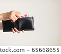 Hands holding a wallet that has Thai banknotes 500 Baht in it. 65668655