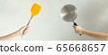 Hands of two people holding the spade of the frying pan and the pot; the concept of fat VS low fat. 65668657