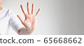 Close-up of a hand palm showing five fingers; the hand signs telling to stop and warn to do not do. 65668662