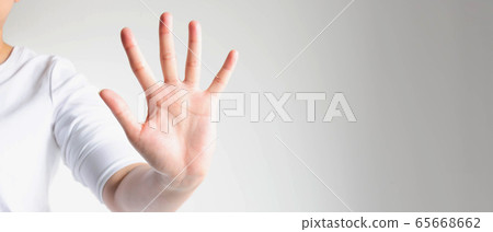 Close-up of a hand palm showing five fingers; the hand signs telling to stop and warn to do not do. 65668662
