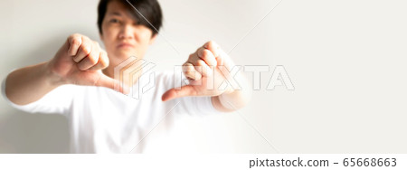 A person is posturing two hands thumbs down to showing feeling dislike or disagree. 65668663