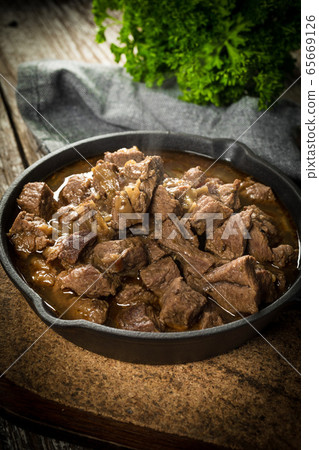 Beef stew in a cast iron skillet. 65669126