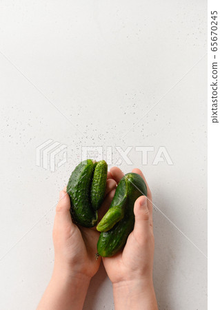Ugly organic abnormal cucumber in child hands Ugly organic abnormal cucumber in child hands 65670245