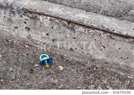 lost pacifier lies on the side of the road 65670500