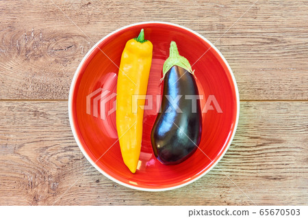 pod of yellow pepper and almost black eggplant on pod of yellow pepper and almost black eggplant on 65670503