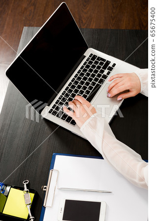 Crop of women's hands lying on the keyboard of a 65675400