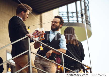Two men talking, celebrating, look happy, have corporate party at office or bar 65675707