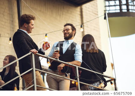 Group of young caucasian people celebrating, look happy, have corporate party at office or bar Group of young caucasian people celebrating, look happy, have corporate party at office or bar 65675709