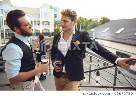 Two men talking, celebrating, look happy, have corporate party at office or bar 65675720