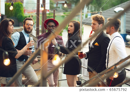 Multiethnic group of people celebrating, look happy, have corporate party at office or bar Multiethnic group of people celebrating, look happy, have corporate party at office or bar 65675792