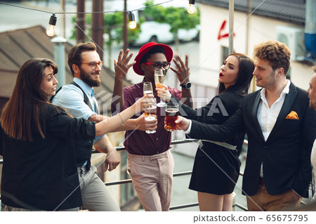 Multiethnic group of people celebrating, look happy, have corporate party at office or bar Multiethnic group of people celebrating, look happy, have corporate party at office or bar 65675795