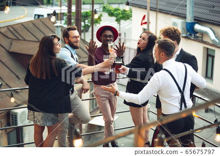 Multiethnic group of people celebrating, look happy, have corporate party at office or bar Multiethnic group of people celebrating, look happy, have corporate party at office or bar 65675797