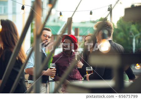 Multiethnic group of people celebrating, look happy, have corporate party at office or bar Multiethnic group of people celebrating, look happy, have corporate party at office or bar 65675799