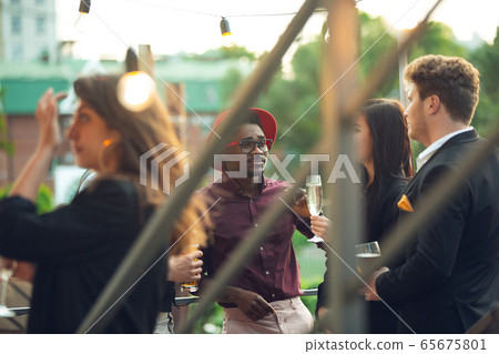 Multiethnic group of people celebrating, look happy, have corporate party at office or bar Multiethnic group of people celebrating, look happy, have corporate party at office or bar 65675801