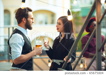 Man and woman celebrating, look happy, have corporate party at office or bar Man and woman celebrating, look happy, have corporate party at office or bar 65675804