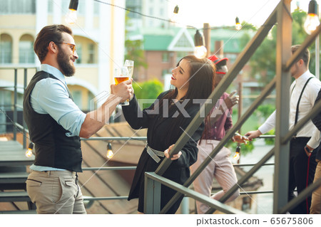 Group of young caucasian people celebrating, look happy, have corporate party at office or bar Group of young caucasian people celebrating, look happy, have corporate party at office or bar 65675806
