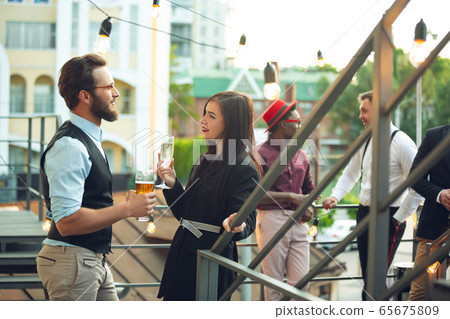 Group of young caucasian people celebrating, look happy, have corporate party at office or bar Group of young caucasian people celebrating, look happy, have corporate party at office or bar 65675809