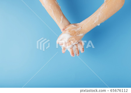 Children's hands in soap suds, on a blue Children's hands in soap suds, on a blue 65676112