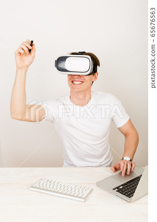 Male using virtual reality headset interacts Male using virtual reality headset interacts 65676563