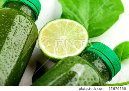 Close up of the lime slice lying between the the bottles of green beverage Close up of the lime slice lying between the the bottles of green beverage 65676566