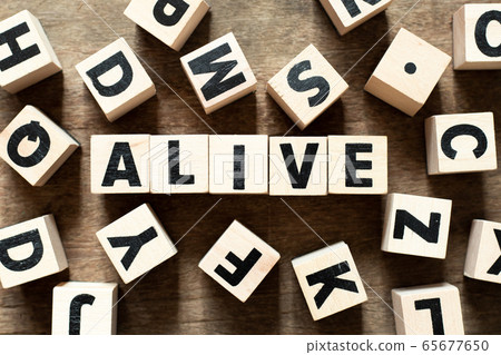 Wood letter block in word alive on wood background Wood letter block in word alive on wood background 65677650