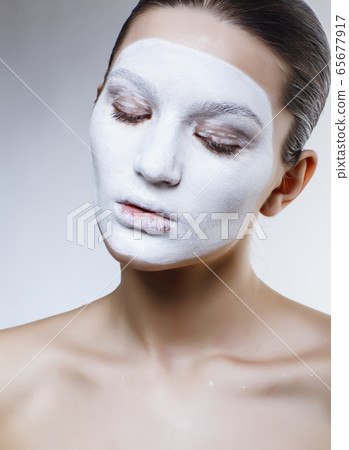 pretty caucasian girl in white mask on face, cosmetic spa concept pretty caucasian girl in white mask on face, cosmetic spa concept 65677917