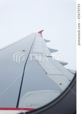 Airplane wing view through window 65679783