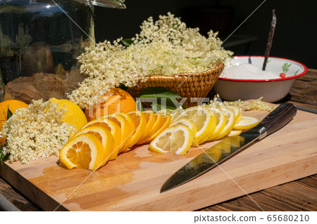 A cutting board with a kitchen knife and a sliced 65680210