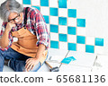 Senior worker rest his chin on his hand, sitting on tiles at construction site. 65681136