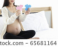 Pregnant Asian woman smiling and happy to be mom and imagine her child will be boy or girl. 65681164