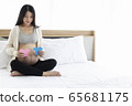 Pregnant Asian woman smiling and happy to be mom and imagine her child will be boy or girl. 65681175
