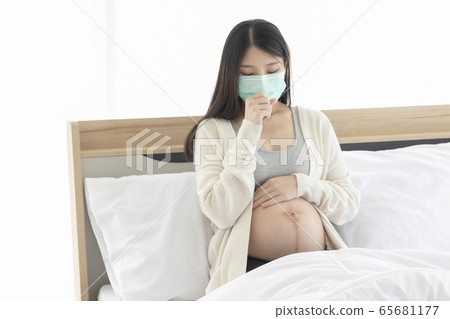 Young Asain woman coughing for effective caused of cold or influenza, wearing mask cover her face. Young Asain woman coughing for effective caused of cold or influenza, wearing mask cover her face. 65681177