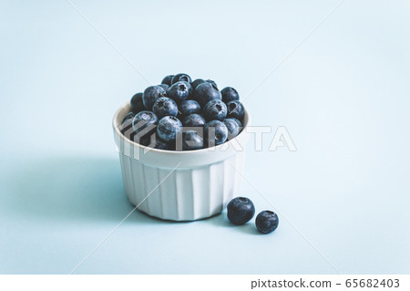 Fresh raw organic blueberry in mug on a blue Fresh raw organic blueberry in mug on a blue 65682403