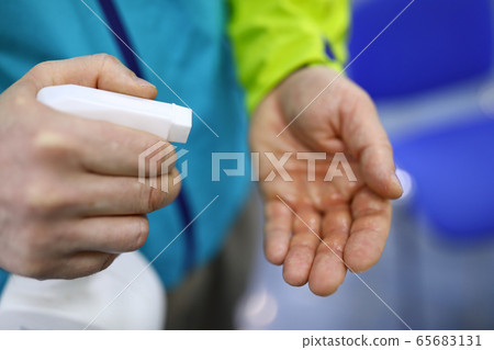 Man hold in hand white bottle of sanitizer Man hold in hand white bottle of sanitizer 65683131