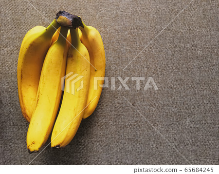 Organic bananas on rustic linen background Organic bananas on rustic linen background 65684245