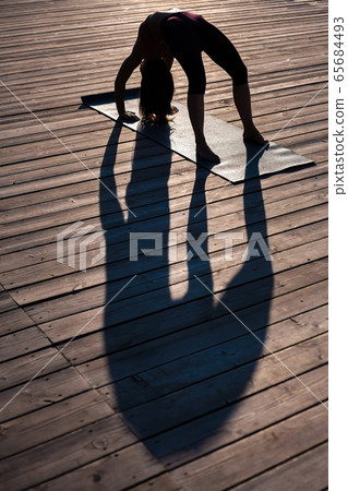 girl demonstrates yoga asana on the wooden 65684493